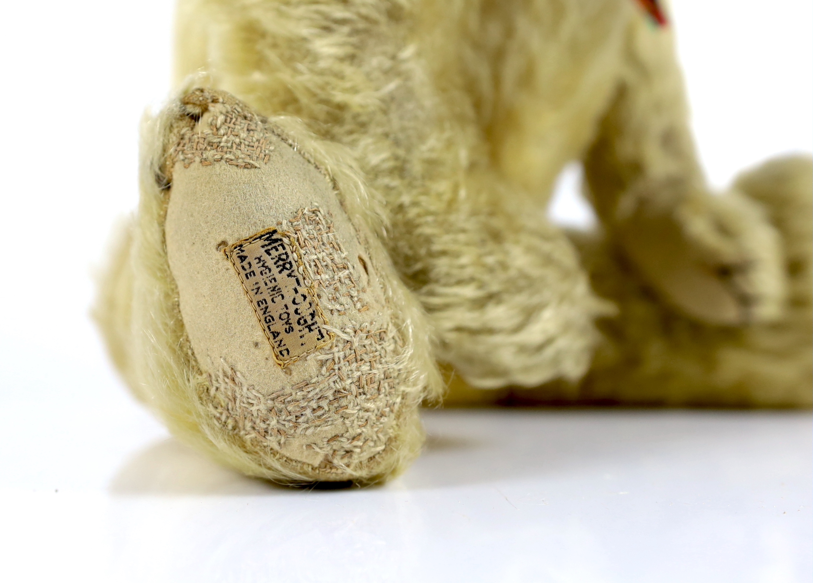 A 1930's Merrythought bear, with label, 44cm, old repair to foot, some hair loss